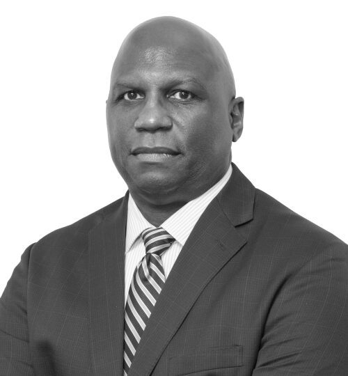 Professional black and white portrait of a man in a suit and striped tie.